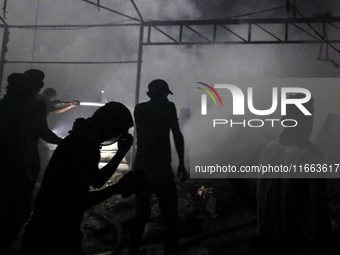 Rescuers work at the site of an Israeli strike on tents sheltering displaced people amid the Israel-Hamas conflict in Deir Al-Balah, Gaza St...