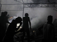 Rescuers work at the site of an Israeli strike on tents sheltering displaced people amid the Israel-Hamas conflict in Deir Al-Balah, Gaza St...