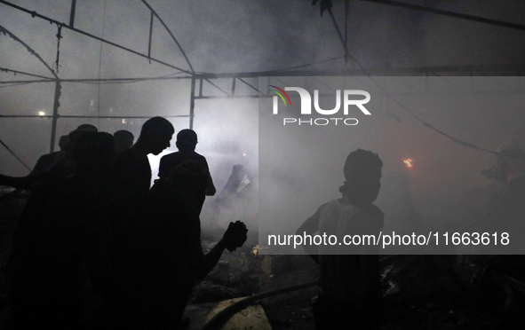 Rescuers work at the site of an Israeli strike on tents sheltering displaced people amid the Israel-Hamas conflict in Deir Al-Balah, Gaza St...