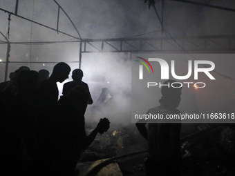 Rescuers work at the site of an Israeli strike on tents sheltering displaced people amid the Israel-Hamas conflict in Deir Al-Balah, Gaza St...