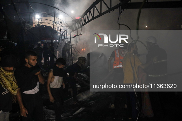 Rescuers work at the site of an Israeli strike on tents sheltering displaced people amid the Israel-Hamas conflict in Deir Al-Balah, Gaza St...