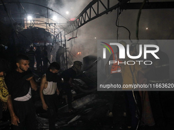 Rescuers work at the site of an Israeli strike on tents sheltering displaced people amid the Israel-Hamas conflict in Deir Al-Balah, Gaza St...