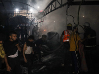 Rescuers work at the site of an Israeli strike on tents sheltering displaced people amid the Israel-Hamas conflict in Deir Al-Balah, Gaza St...