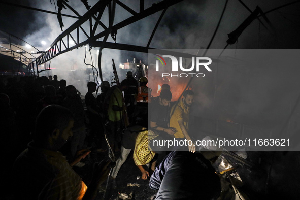 Rescuers work at the site of an Israeli strike on tents sheltering displaced people amid the Israel-Hamas conflict in Deir Al-Balah, Gaza St...