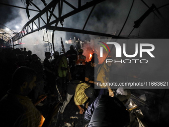 Rescuers work at the site of an Israeli strike on tents sheltering displaced people amid the Israel-Hamas conflict in Deir Al-Balah, Gaza St...