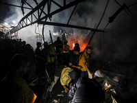 Rescuers work at the site of an Israeli strike on tents sheltering displaced people amid the Israel-Hamas conflict in Deir Al-Balah, Gaza St...