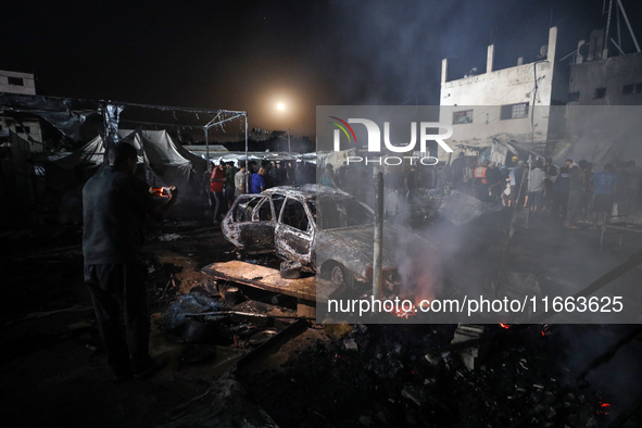 Rescuers work at the site of an Israeli strike on tents sheltering displaced people amid the Israel-Hamas conflict in Deir Al-Balah, Gaza St...