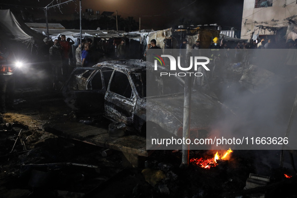 Rescuers work at the site of an Israeli strike on tents sheltering displaced people amid the Israel-Hamas conflict in Deir Al-Balah, Gaza St...