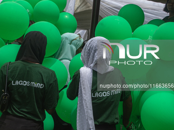 Volunteers hold ceremonial green balloons, symbolizing hope and resilience in the face of mental health challenges, during the launch of the...