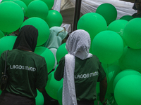 Volunteers hold ceremonial green balloons, symbolizing hope and resilience in the face of mental health challenges, during the launch of the...