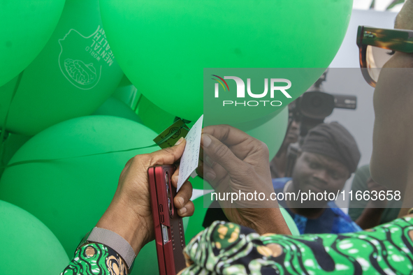 Dr. Kemi Ogunyemi, Special Adviser on Health to the Governor, Lagos State, attaches a card with words of hope to the ceremonial green balloo...