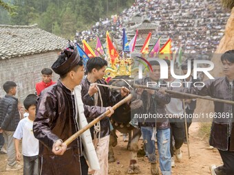 People watch a bullfight at a bullfighting pond in Congjiang County, Guizhou Province, China, on October 13, 2024. (