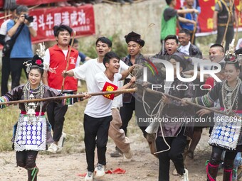 People watch a bullfight at a bullfighting pond in Congjiang County, Guizhou Province, China, on October 13, 2024. (