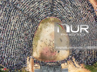 People watch a bullfight at a bullfighting pond in Congjiang County, Guizhou Province, China, on October 13, 2024. (