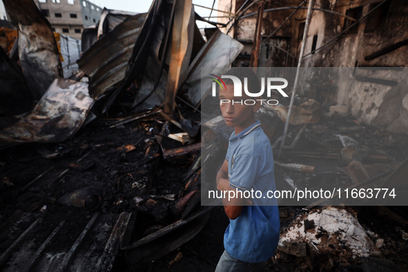 A Palestinian boy looks at the site of an Israeli strike on tents sheltering displaced people amid the Israel-Hamas conflict at Al-Aqsa Mart...