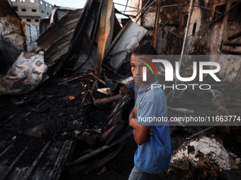 A Palestinian boy looks at the site of an Israeli strike on tents sheltering displaced people amid the Israel-Hamas conflict at Al-Aqsa Mart...