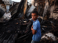 A Palestinian boy looks at the site of an Israeli strike on tents sheltering displaced people amid the Israel-Hamas conflict at Al-Aqsa Mart...