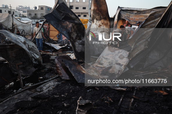 A Palestinian boy looks at the site of an Israeli strike on tents sheltering displaced people amid the Israel-Hamas conflict at Al-Aqsa Mart...