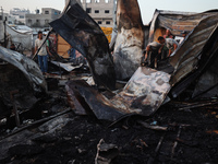 A Palestinian boy looks at the site of an Israeli strike on tents sheltering displaced people amid the Israel-Hamas conflict at Al-Aqsa Mart...