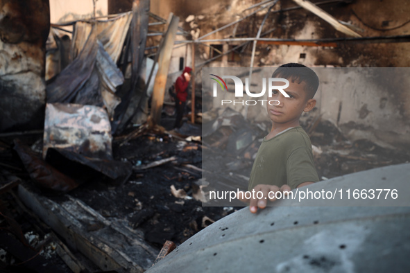 A Palestinian boy looks at the site of an Israeli strike on tents sheltering displaced people amid the Israel-Hamas conflict at Al-Aqsa Mart...