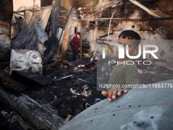 A Palestinian boy looks at the site of an Israeli strike on tents sheltering displaced people amid the Israel-Hamas conflict at Al-Aqsa Mart...