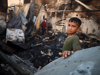 A Palestinian boy looks at the site of an Israeli strike on tents sheltering displaced people amid the Israel-Hamas conflict at Al-Aqsa Mart...