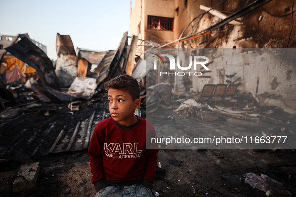 A Palestinian boy looks at the site of an Israeli strike on tents sheltering displaced people amid the Israel-Hamas conflict at Al-Aqsa Mart...