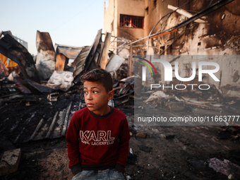 A Palestinian boy looks at the site of an Israeli strike on tents sheltering displaced people amid the Israel-Hamas conflict at Al-Aqsa Mart...