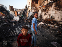 Palestinians survey the damage at the site of an Israeli strike on tents sheltering displaced people at Al-Aqsa Martyrs hospital in Deir Al-...