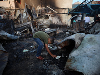 Palestinians survey the damage at the site of an Israeli strike on tents sheltering displaced people at Al-Aqsa Martyrs hospital in Deir Al-...