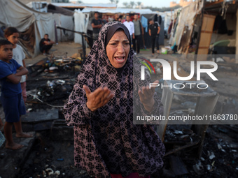 A Palestinian woman observes the site of an Israeli strike on tents sheltering displaced people, amid the Israel-Hamas conflict, at Al-Aqsa...