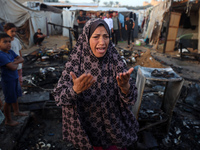 A Palestinian woman observes the site of an Israeli strike on tents sheltering displaced people, amid the Israel-Hamas conflict, at Al-Aqsa...