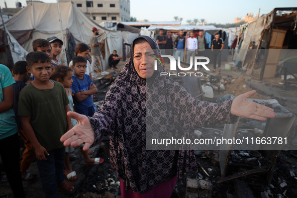 A Palestinian woman observes the site of an Israeli strike on tents sheltering displaced people, amid the Israel-Hamas conflict, at Al-Aqsa...