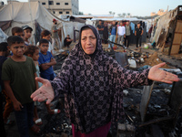 A Palestinian woman observes the site of an Israeli strike on tents sheltering displaced people, amid the Israel-Hamas conflict, at Al-Aqsa...