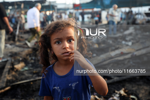 A Palestinian girl observes the site of an Israeli strike on tents sheltering displaced people amid the Israel-Hamas conflict at Al-Aqsa Mar...