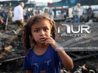 A Palestinian girl observes the site of an Israeli strike on tents sheltering displaced people amid the Israel-Hamas conflict at Al-Aqsa Mar...