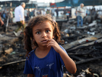 A Palestinian girl observes the site of an Israeli strike on tents sheltering displaced people amid the Israel-Hamas conflict at Al-Aqsa Mar...