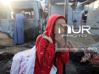 Palestinians survey the damage at the site of an Israeli strike on tents sheltering displaced people at Al-Aqsa Martyrs hospital in Deir Al-...