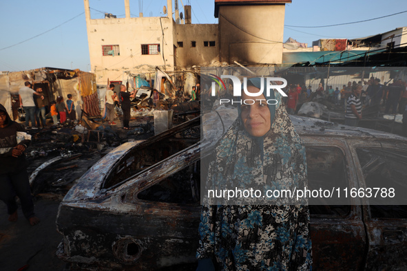 A Palestinian woman observes the site of an Israeli strike on tents sheltering displaced people, amid the Israel-Hamas conflict, at Al-Aqsa...