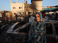 A Palestinian woman observes the site of an Israeli strike on tents sheltering displaced people, amid the Israel-Hamas conflict, at Al-Aqsa...