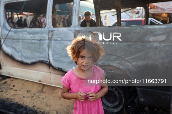 Palestinians survey the damage at the site of an Israeli strike on tents sheltering displaced people at Al-Aqsa Martyrs hospital in Deir Al-...