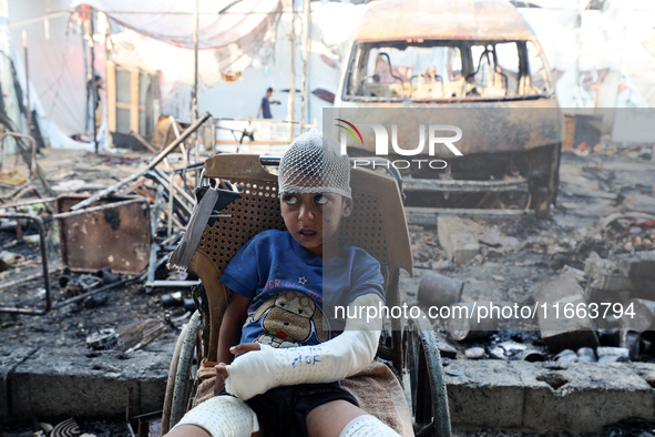 A Palestinian boy looks at the site of an Israeli strike on tents sheltering displaced people amid the Israel-Hamas conflict at Al-Aqsa Mart...