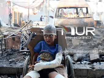 A Palestinian boy looks at the site of an Israeli strike on tents sheltering displaced people amid the Israel-Hamas conflict at Al-Aqsa Mart...