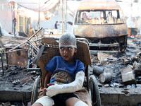 A Palestinian boy looks at the site of an Israeli strike on tents sheltering displaced people amid the Israel-Hamas conflict at Al-Aqsa Mart...