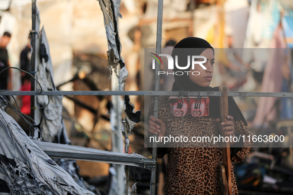 A Palestinian woman observes the site of an Israeli strike on tents sheltering displaced people, amid the Israel-Hamas conflict, at Al-Aqsa...