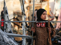 A Palestinian woman observes the site of an Israeli strike on tents sheltering displaced people, amid the Israel-Hamas conflict, at Al-Aqsa...