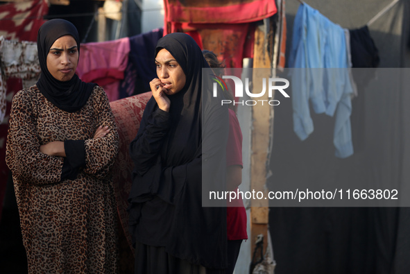 Palestinians survey the damage at the site of an Israeli strike on tents sheltering displaced people at Al-Aqsa Martyrs hospital in Deir Al-...