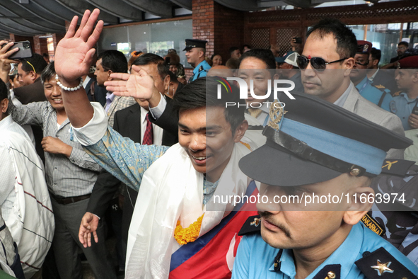 Nepalese youngest record holder climber Nima Rinji Sherpa waves to the media and supporters after arriving at Tribhuvan International Airpor...