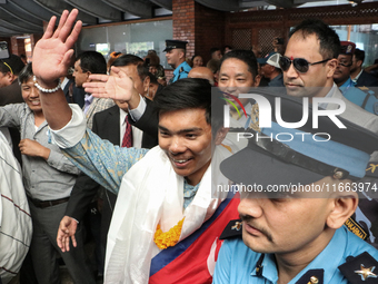 Nepalese youngest record holder climber Nima Rinji Sherpa waves to the media and supporters after arriving at Tribhuvan International Airpor...