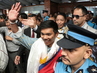 Nepalese youngest record holder climber Nima Rinji Sherpa waves to the media and supporters after arriving at Tribhuvan International Airpor...